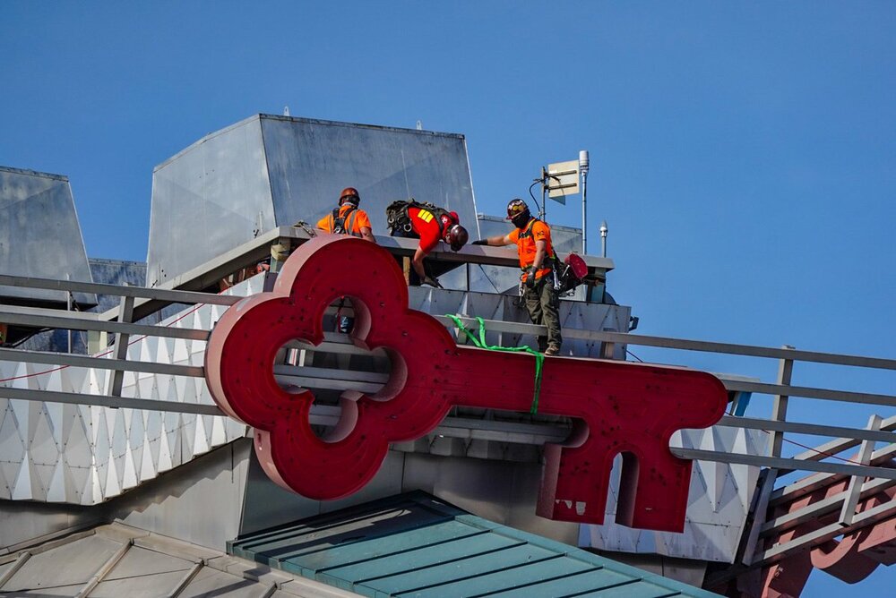 A helicopter operation at Climate Pledge Arena removes the former signage Wednesday, forging the way for a new “crown ID” and new era with Amazon-OVG-NHL Seattle partnership.  By Bob Condor